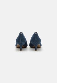 Blue suede high-heeled shoes featuring a classic design, pointed toe, and a small accent logo on the back heel.