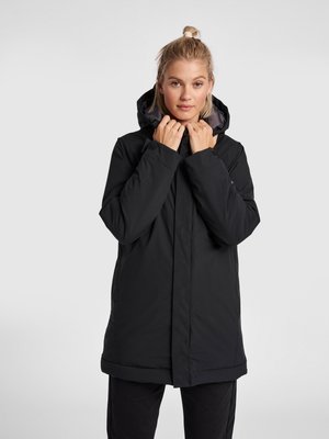 Schwarze isolierte Jacke mit Kapuze, ausgestattet mit einem Frontreißverschluss, seitlichen Taschen und einem geraden Schnitt. Glatte Textur und strapazierfähiges Material.