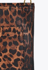 Borsa con stampa leopardata in morbida ecopelle marrone e nera, dotata di tasca e finiture dorate nella parte superiore.