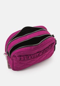 Borsa a tracolla quilted viola con accenti arricciati, dotata di tre scomparti con zip e una tracolla in catena. Finitura in nylon lucido.