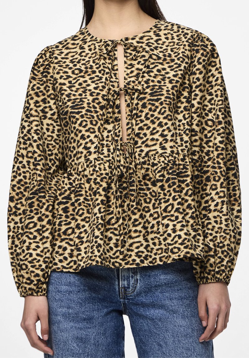 Blusa con stampa leopardata, collo rotondo, maniche lunghe a sbuffo, chiusura con fiocco e vita arricciata. Realizzata in tessuto morbido con una finitura texturizzata.