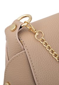 Borsa a tracolla in pelle beige con angolo caratterizzato da una superficie texture, hardware dorato e attacco della catena con dettaglio di chiusura a scatto.