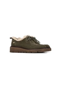 Zapatos de ante verde oliva con forro y cordones de felpa beige, que presentan una suela de goma marrón gruesa con tracción estriada.