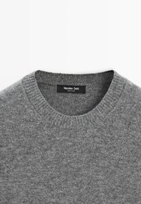 Maglione grigio a collo rotondo realizzato in tessuto knit, con una texture morbida e colletto a costine. L'etichetta riporta "Massimo Dutti."