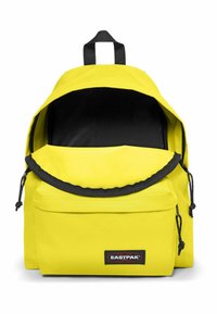 Gul Eastpak ryggsäck med ett rymligt svart inre, elastisk dragsnodd för stängning och en framficka; tillverkad av hållbart tyg.