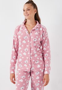 Set de pijamale din flanel roz, cu dungi, având modele cu urși albi și inimi. Camasa cu nasturi și guler, mâneci lungi și pantaloni cu talie elastică.