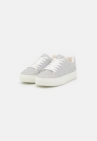 Silver sparkling sneakers with a textured upper, white laces, and a thick white sole, featuring a covered toe and smooth heel.