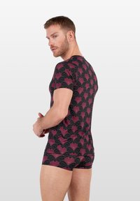 Chemise à motifs noir et bordeaux avec des manches courtes, arborant un design de ventilateur. La coupe est ajustée, et le matériau semble lisse et extensible.