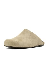 Mule beige en daim à enfiler, avec bout fermé et semelle plate noire, conçue pour une utilisation intérieure ou décontractée.