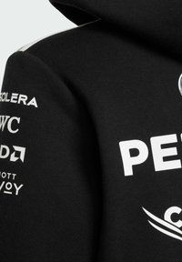 Sudadera negra con capucha que presenta logotipos y texto en blanco impresos en la manga, con una textura suave y un diseño de capucha con cordón.