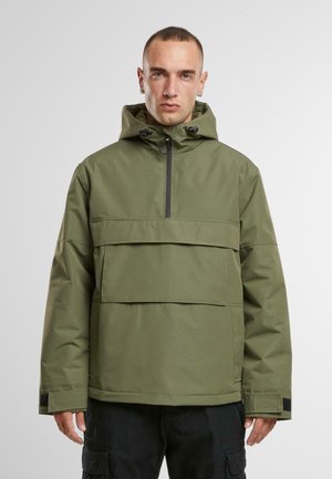 Giacca a windbreaker verde oliva con tasca frontale, chiusura a metà zip, cappuccio regolabile e dettagli neri ai polsini. Tessuto di finitura liscia.