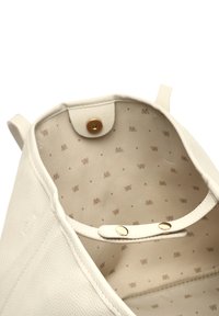 Witte leren tote bag met een textuur aan de buitenkant. De binnenkant heeft een lichtgekleurde voering met een subtiel patroon en een drukknoopsluiting.