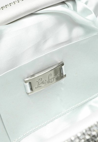 Intérieur de sac à main en satin blanc avec une plaque logo argentée et une texture lisse. Présente un design froncé et une rangée de petits strass.