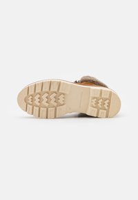 Beige rubber sole of a size 37 boot with deep treads, visible brand name "Scotch & Soda," and brown fur lining at the heel.