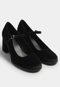 Décolleté Mary Jane in velluto nero con punta tonda, tacco a blocco chunky e una striscia stretta con una piccola fibbia dorata. Design semplice con una texture liscia.