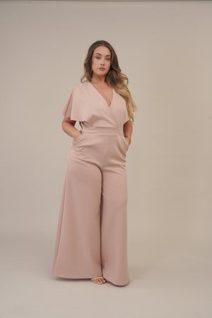 Pale pink jumpsuit with short, cap-like sleeves, v-neck, wide legs, textured fabric, and side pockets. Accented with gold-tone bangles.