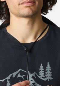 Black t-shirt with a graphic print of trees and mountains. A black cord with a small toggle is secured around the neck.