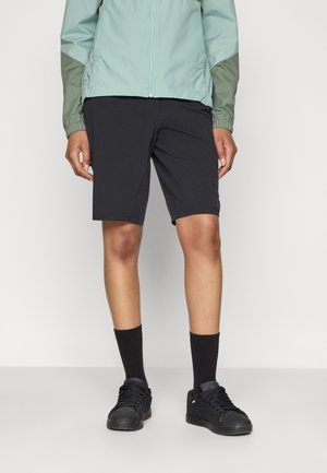 Black athletic shorts, made of lightweight fabric, above the knee length. Paired with black socks and sneakers, and a mint green jacket.
