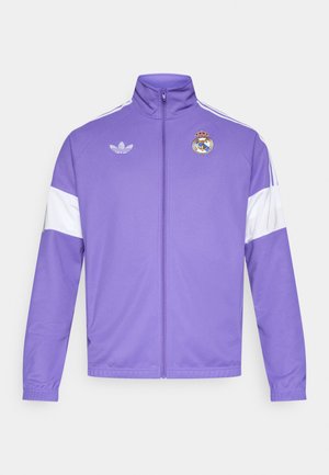 Purple sports jacket with white accents, full zipper, high collar, and embroidered Real Madrid logo on the left chest. Adidas logo on the upper left.