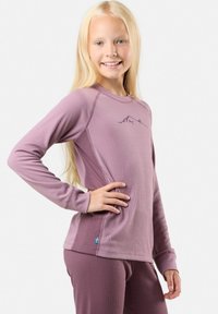 Pitkähiha, mauven värinen lämpöpaita, jossa on ribbitetty pinta ja vuoristokuvio rinnassa. Kevyt kangas ja tiukka istuvuus mukavuuden ja lämpimyyden takaamiseksi.