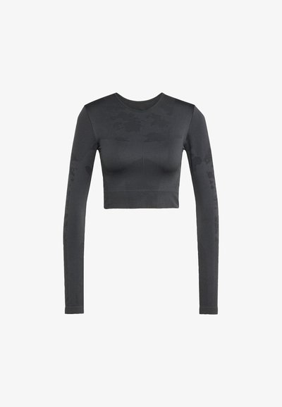 Pitkähihainen cropped-paita tummanharmaana, tekstuuripinnalla ja sävyttävällä camouflage-kuviolla. Varustettu pyöreällä kaula-aukolla ja istuvalla siluetilla.