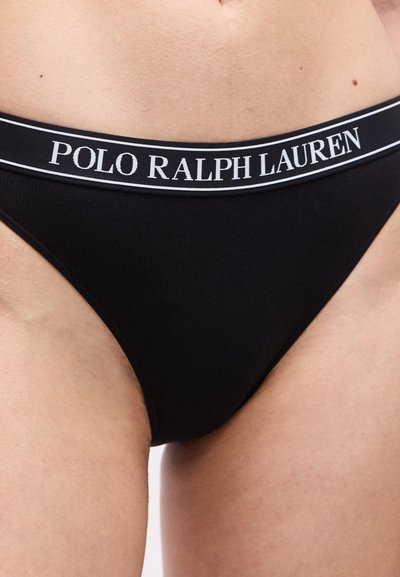 Μαύρα εσώρουχα με μια ζώνη μέσης με τη μάρκα «Polo Ralph Lauren», φορεμένα στην κάτω κοιλιακή χώρα και τα πάνω μηρά ενός ατόμου.