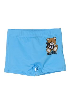 Costume da bagno per bambini azzurro chiaro con vita elastica, caratterizzato da una grafica di un orsacchiotto e dal testo "Toy Moschino" sul lato destro anteriore.