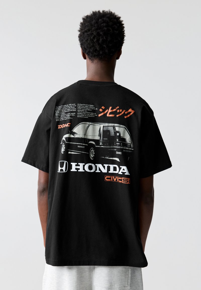 Čierne bavlnené tričko s okrúhlym výstrihom, na zadnej strane s grafikou automobilu Honda Civic, s textom v japončine a bielymi a oranžovými akcentmi.