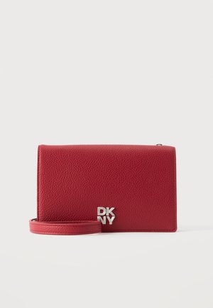 Rode leren crossbodytas met zilverkleurig DKNY-logo op de voorkant en een bijpassende rode band, tegen een effen witte achtergrond.