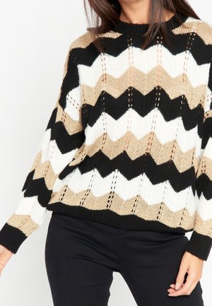 Neulottu neule, jossa on mustavalko-beige chevron-kuvio. Rentoa mallia, pitkät hihat ja resorinen pyöreä pääntie.