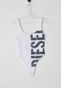 Maillot de bain une pièce blanc avec un grand logo "DIESEL" gris foncé sur le côté droit. Fabriqué en matériau lisse et extensible, avec des bretelles fines.