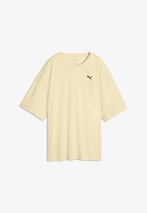 Jasnobeżowy T-shirt z krótkim rękawem, okrągłym dekoltem i małym czarnym logo Puma na lewej piersi.
