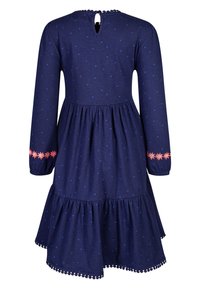 Námořnická modrá dlouhá šaty s světle modrými puntíky, růžovou květinovou výšivkou na rukávech, nařaseným pasem a volánkovým lemem s bambulkami.