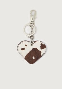 Hjerteformet nøkkelring med brun og hvit kuttemønster festet til sølvfarget metallring og klaff.