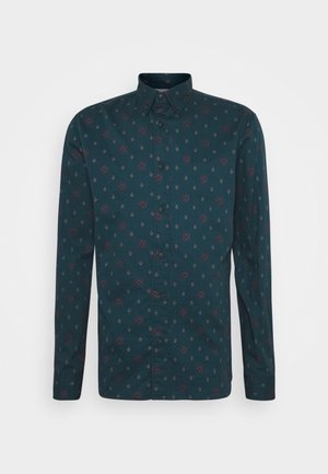 Langarmshirt van donker teal stof met een bloemen- en diamantpatroon in bordeauxrood en wit, met een kraag en knoopsluiting aan de voorkant.
