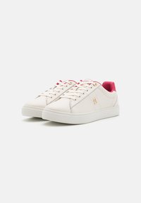 Weiße synthetische Sneakers mit rosa Akzenten, runder Zehenform, Schnürdesign, strukturiertem Futter und glatter Oberfläche. Goldene Brandingdetails an der Seite.