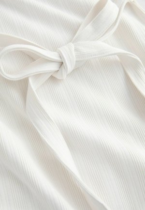 Hvidt stof med lodret ribbet struktur og detaljeret bundet sløjfe. Glat overflade med blød fald og subtil glans.