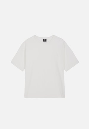 Maglietta bianca semplice a maniche corte con scollo tondo e piccola etichetta nera del marchio sul retro del colletto su sfondo bianco.