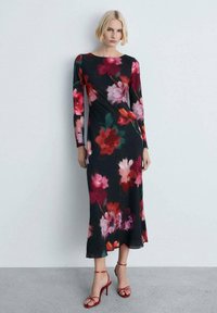 Rochie neagră cu mânecă lungă, cu imprimeu floral în nuanțe de roz și roșu; material neted; fanta pe lateral; asortată cu sandale roșii cu bretele.