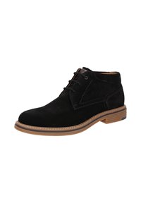 Stivali alla caviglia in suede nero con punta arrotondata, chiusura con lacci e suola in gomma marrone a contrasto. Presentano dettagli cuciti sulla parte superiore.