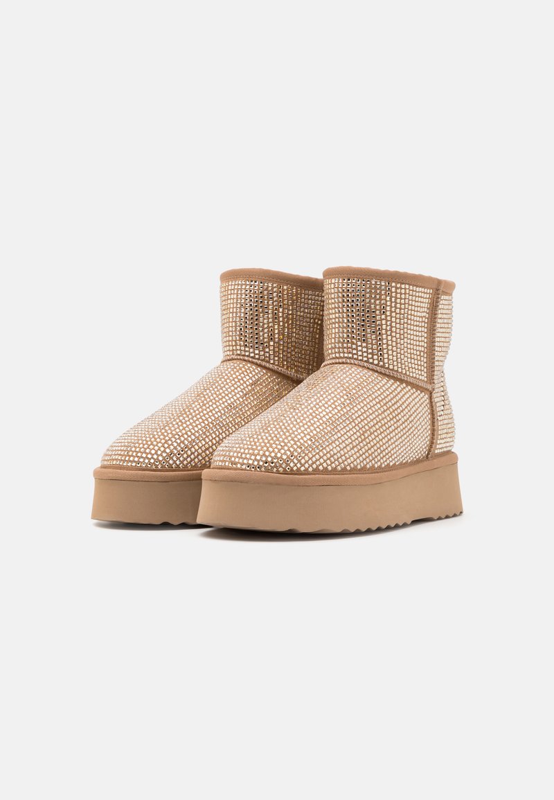 Kurze Ankle Boots aus beigem Wildleder, bedeckt mit metallischen Strasssteinen, mit einer strukturierten Zwischensohle und einer flexiblen Gummisohle.