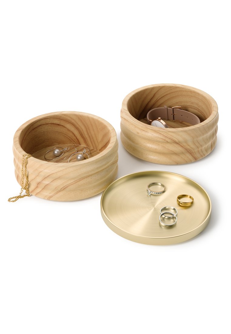 Holzschalen zur Schmuckaufbewahrung mit natürlicher Maserung, eine hält eine Uhr, eine andere Ohrringe und eine Halskette; goldene runde Schale mit Ringen.