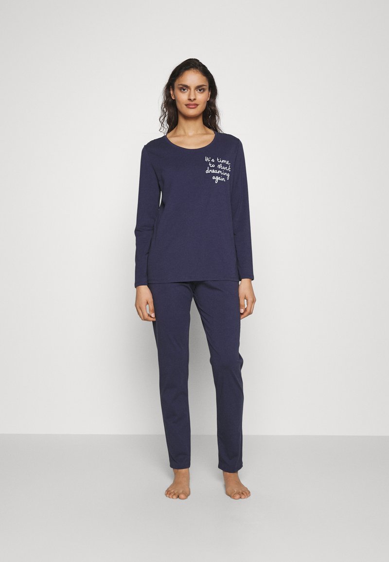 Marinblå långärmad pyjamaströja med vit broderad text; tillsammans med matchande åtsittande byxor. Bomullstyg, avslappnad passform.