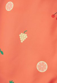 Koralen material z gladko teksturo, ki vsebuje raztresene vzorce limoninih rezin, grozdja, višnjev in zelenih listov.
