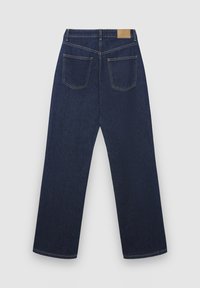 Jean en denim bleu foncé à coupe droite, avec deux poches arrière et une étiquette en cuir beige sur la ceinture. Conception classique et texture robuste.
