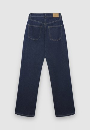 Jean en denim bleu foncé à coupe droite, avec deux poches arrière et une étiquette en cuir beige sur la ceinture. Conception classique et texture robuste.