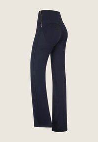 Löysät tummansiniset leggingit, joissa on istuva malli ja korkea vyötärö, sekä näkyvä kultainen vetoketju takana. Pehmeä ja sileä kangas.