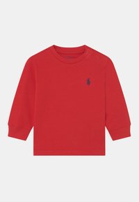 Röd långärmad skjorta i bomull med rund halsringning, två tryckknappar på axeln och en liten marinblå hästsymbol på bröstet.