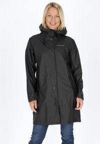 Black waterproof raincoat with a hood, snap buttons, two side pockets, and adjustable hem, displayed on a person against a white background.