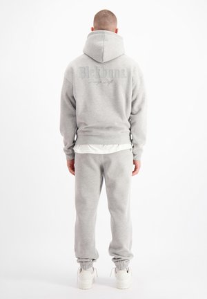 Grijze hoodie met groot logo op de achterkant, gecombineerd met bijpassende sweats. Zachte stof, comfortabele pasvorm, ribgebreide manchetten en elastische tailleband.